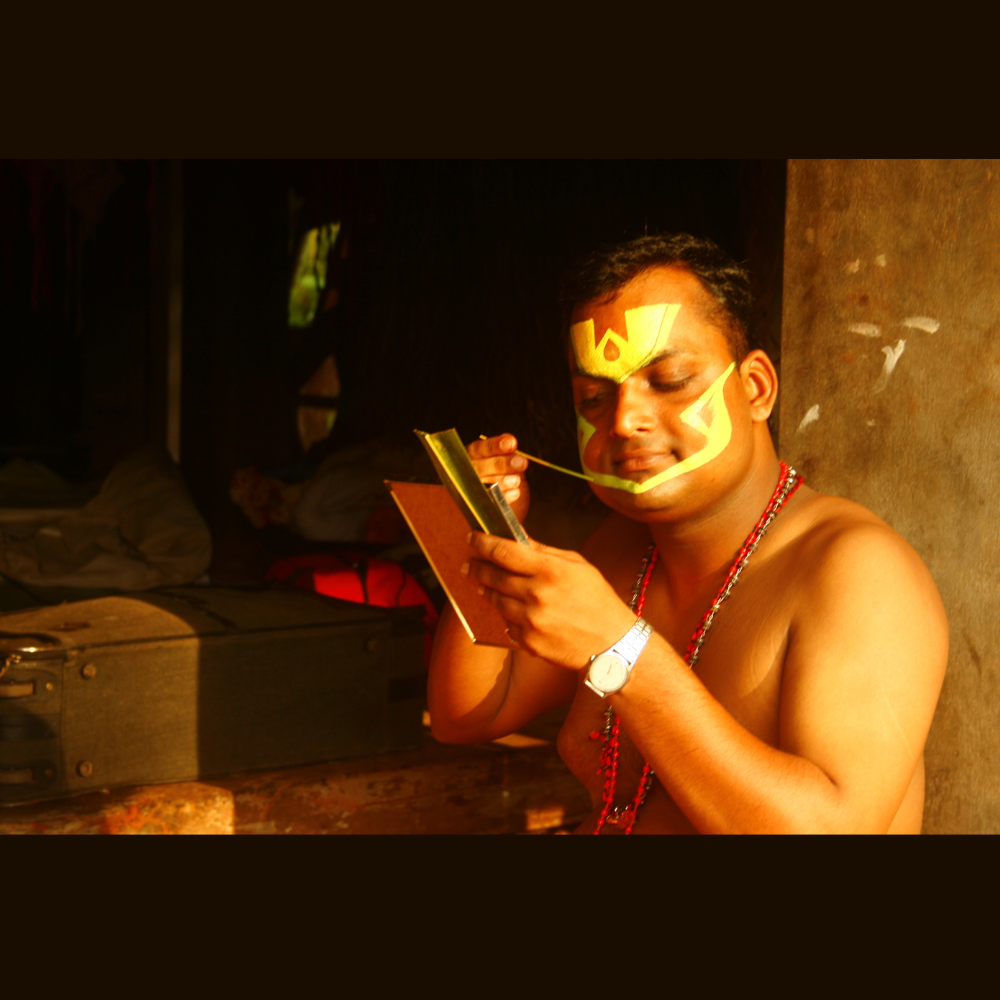 Close-up of a Kathakali face paint performer’s vibrant face paint, with bold colors and intricate patterns.