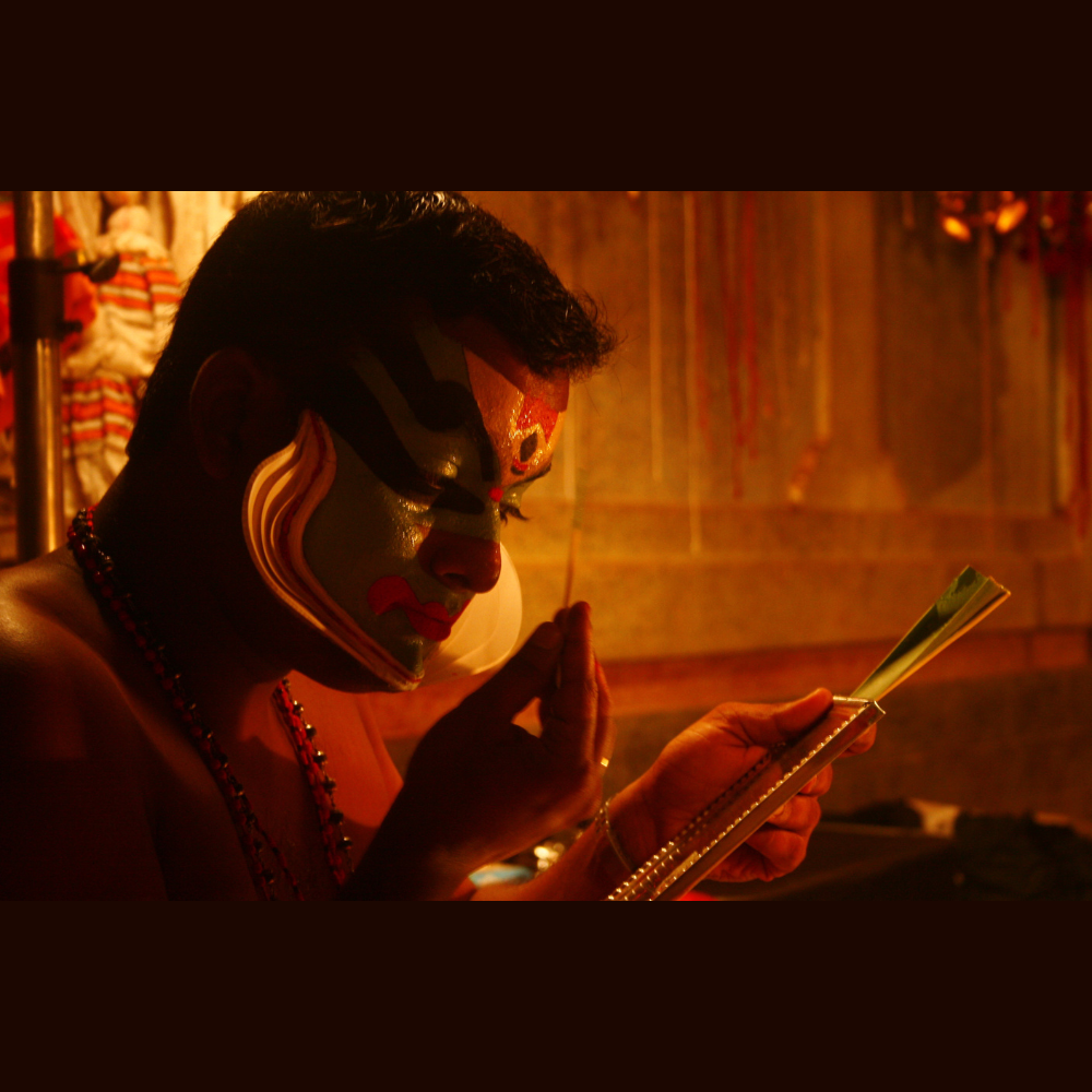 Close-up of a Kathakali face paint performer’s vibrant face paint, with bold colors and intricate patterns.