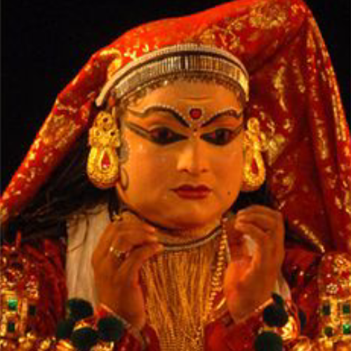 Kathakali actors in elaborate costume and makeup performing on stage with vibrant expressions.