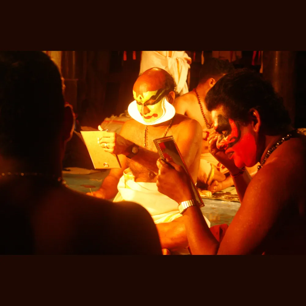 Traditional Kathakali dancer wearing a vibrant costume with elaborate headgear and face makeup