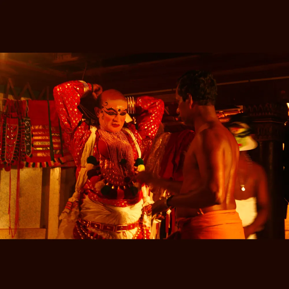 Traditional Kathakali dancer wearing a vibrant costume with elaborate headgear and face makeup