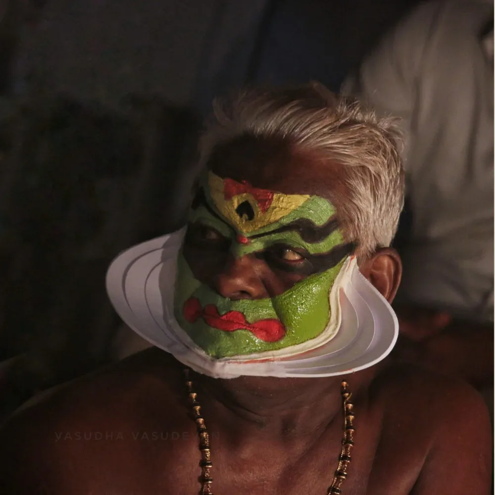 Traditional Kathakali dancer wearing a vibrant costume with elaborate headgear and face makeup