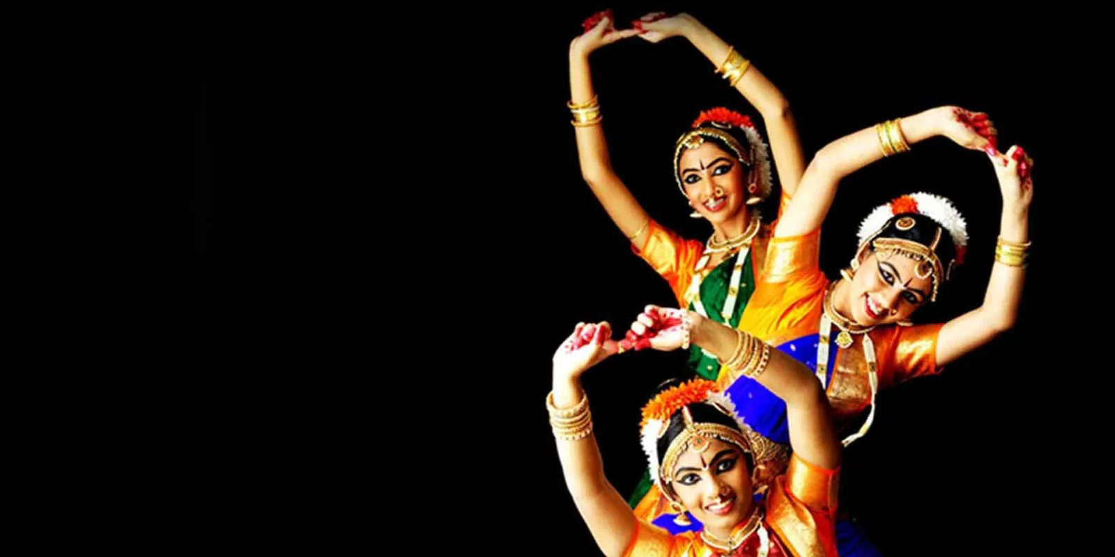 Young Kuchipudi dancer in vibrant costume performing traditional Indian dance move with expressive gestures.