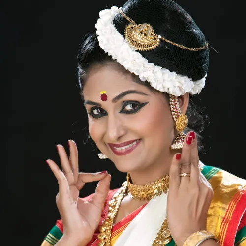 Graceful Mohiniyattam dancer in traditional attire performing with expressive hand gestures.