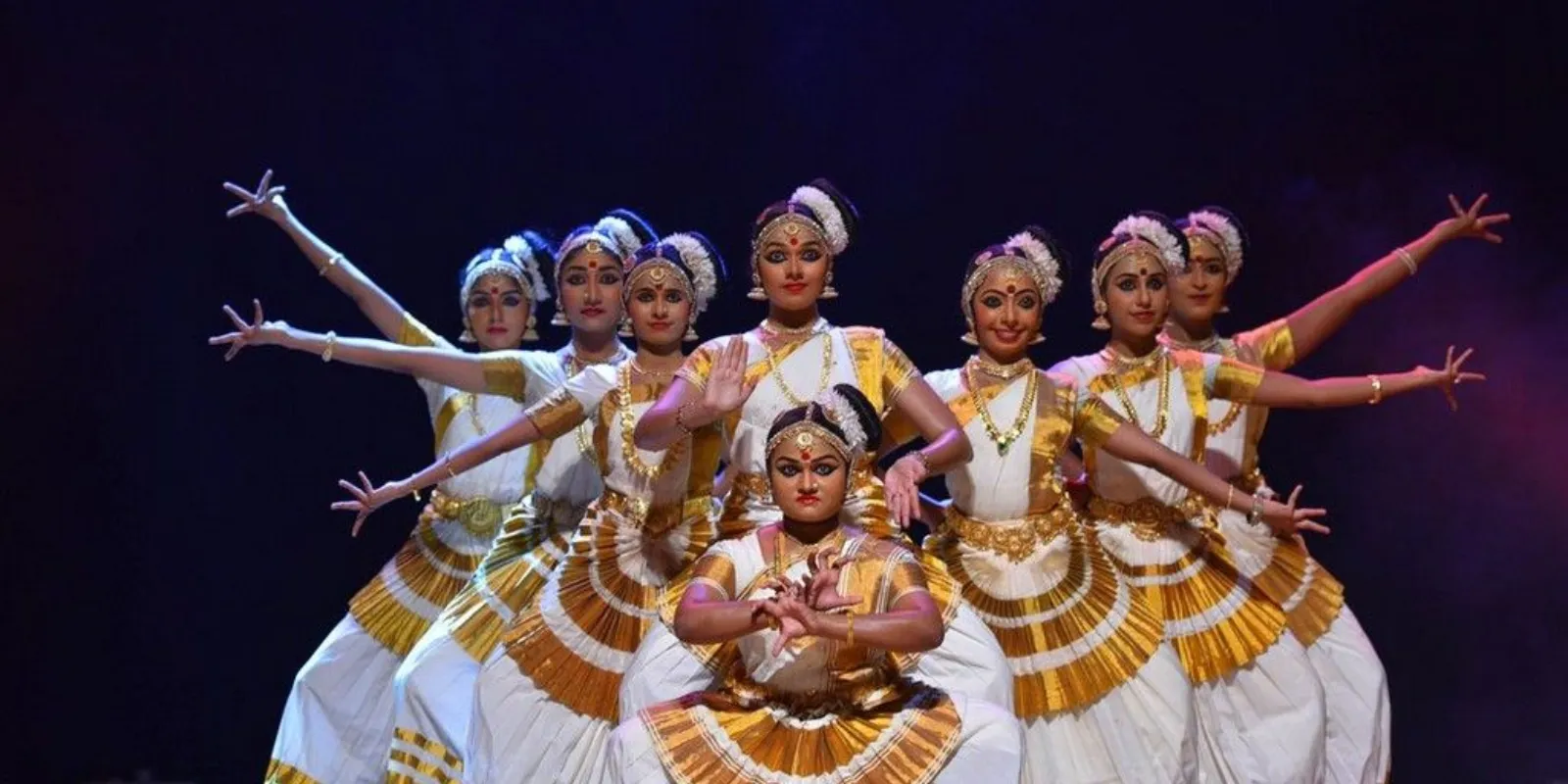 Graceful Mohiniyattam dancer in traditional attire performing with expressive hand gestures.