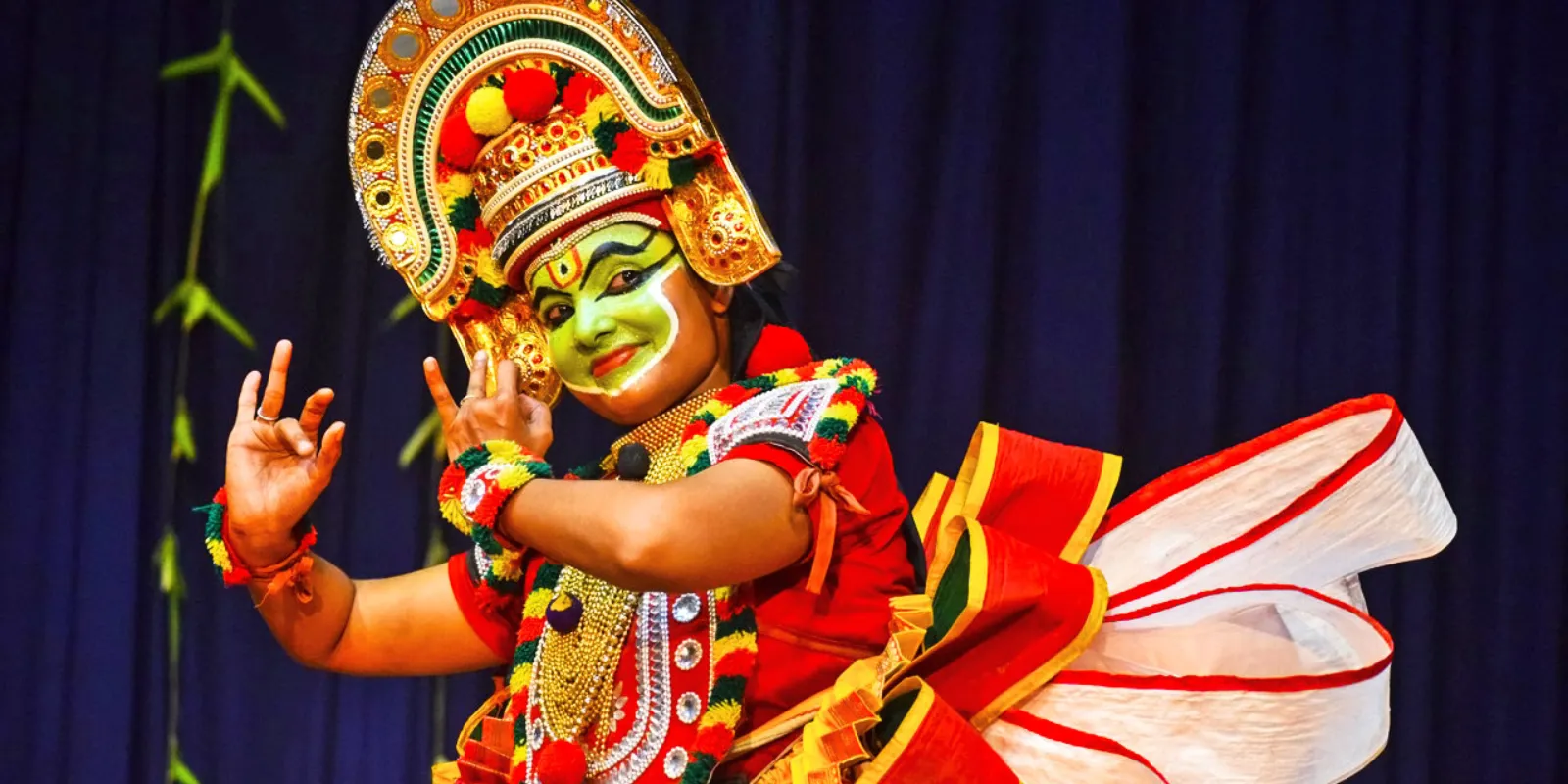 Ottam Thullal performer in colorful costume showcasing lively dance movements.
