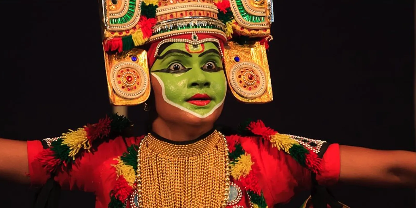 Ottam Thullal performer in colorful costume showcasing lively dance movements.