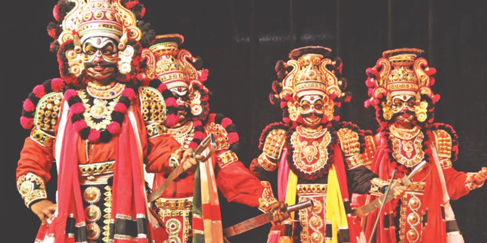 Yakshaganam performer in colorful costume showcasing dramatic expressions and lively dance on stage