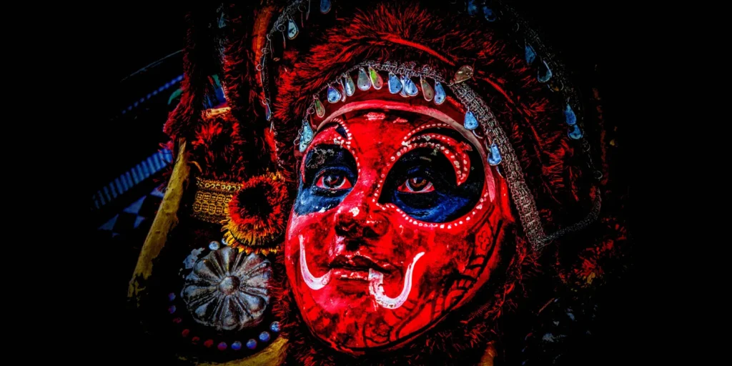 Theyyattam performer in vibrant costume enacting a powerful ritual dance filled with energy and tradition.